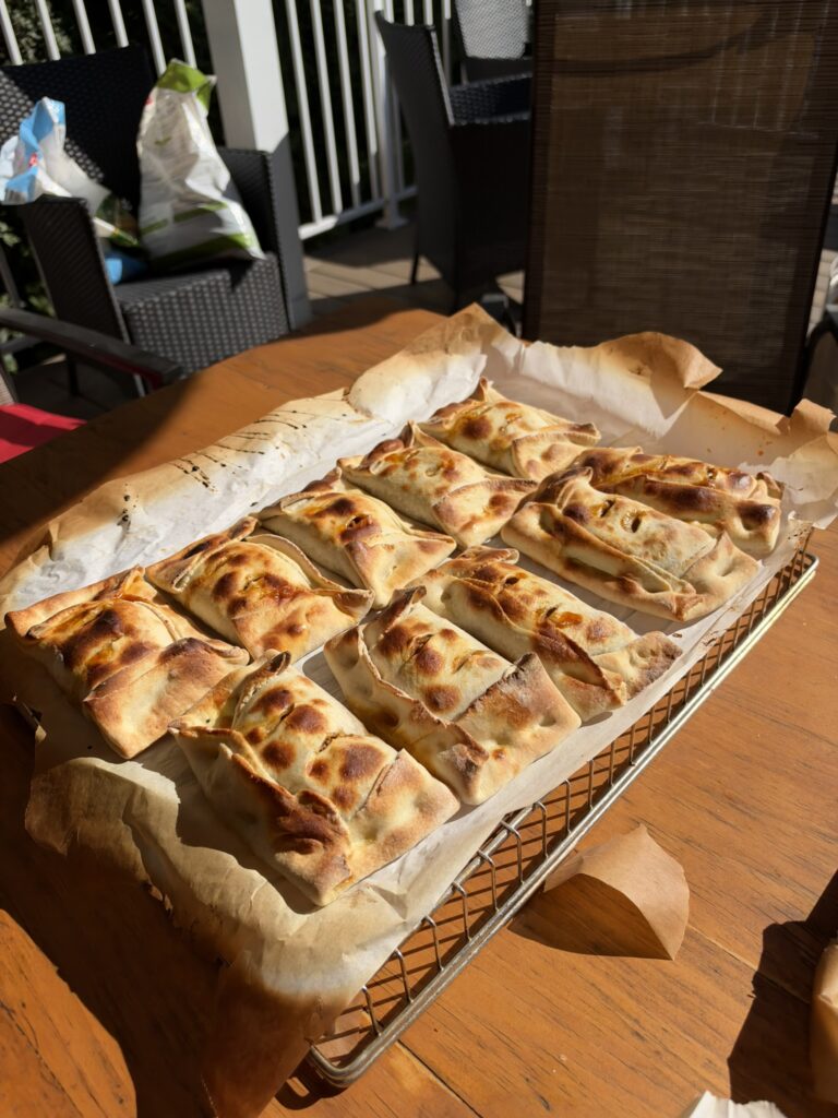 Empanadas chiliennes dorées sortant du four, sur du papier parchemin